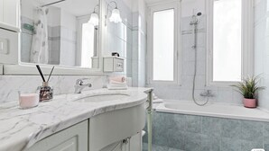 A modern bathroom with a marble sink, a large mirror, a shower, and a potted plant. - Two-room Apartment San Siro-fiera Milano M5 Lilac Segesta (Milan)