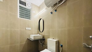 Un bany modern amb vàter, rentapel i plat de dutxa.