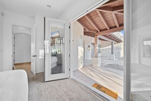 A modern interior with a glass door leading to an outdoor area with a wooden ceiling.
