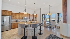 A modern kitchen with granite countertops, stainless steel appliances, and wooden cabinets. - Casa Verde 4 Bedroom Home by RedAwning (Scottsdale)