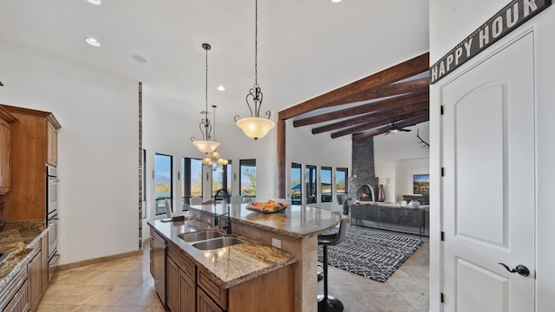 A spacious kitchen with a large island, pendant lighting, and a view to the outside. - Casa Verde 4 Bedroom Home by RedAwning (Scottsdale)