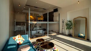 Un salon moderne avec un canapé, une table basse et un grand miroir.