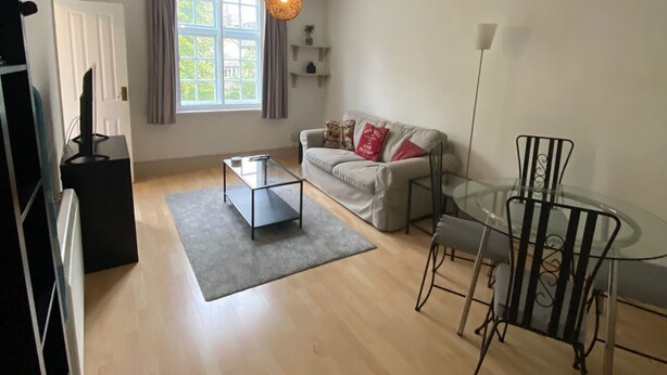 A living room with a sofa, coffee table, and glass dining table. - Apartment - Sleeps 2 & Great Transport Links (London)