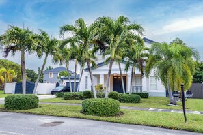 A residential house with a front yard, palm trees, and a mailbox. - Miami Getaway Heated Pool House & Pool Table Villa (Miami)