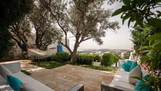 Une terrasse avec un hamac, des sièges d’extérieur et une vue sur la ville.