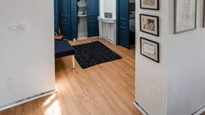 Un hall d’entrée spacieux, doté d’un plancher en bois, d’un tapis noir et d’un luminaire au plafond.