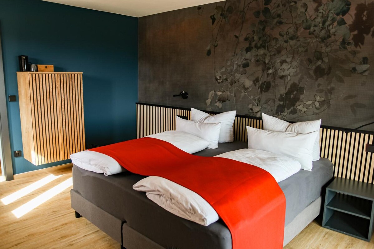 Un dormitorio moderno con una cama, un armario de madera y una pared con textura.