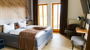A modern bedroom with a bed, a desk, and a chair. - DAS PALMBERGER (Spiegelau)