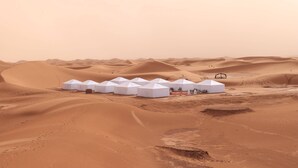 Una hilera de tiendas blancas en un paisaje desértico.