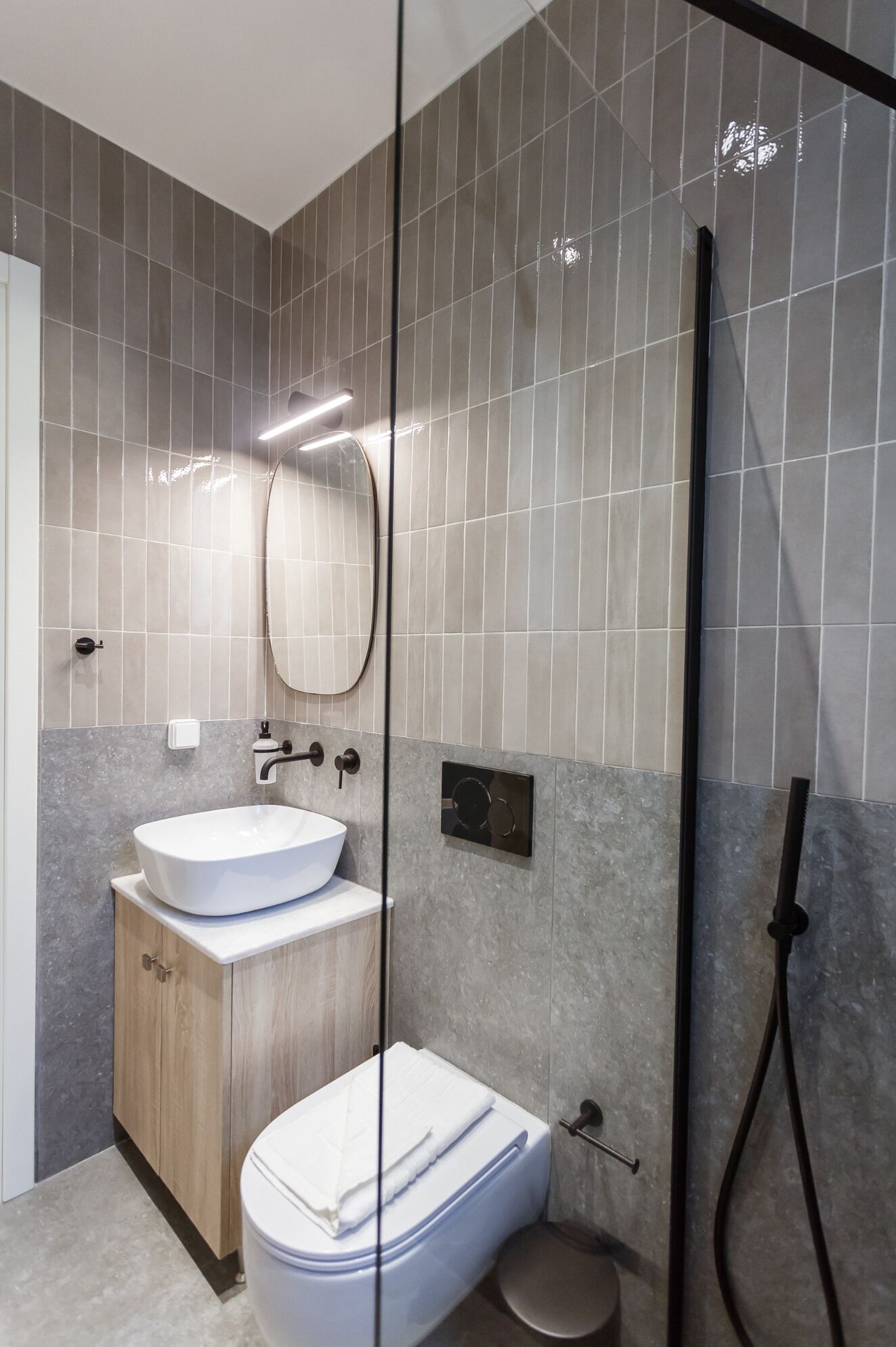 Ein modernes Badezimmer mit einer freistehenden Badewanne, einem Waschbecken mit Holdekor und einer Toilette.