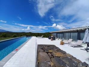 A swimming pool with lounge chairs and a view of mountains. - Pico Terrace (Madalena)