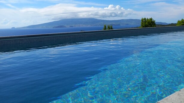 A clear blue sky, a swimming pool, and distant mountains. - Pico Terrace (Madalena)