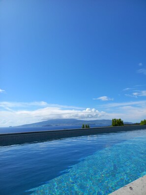 Un ciel d’un bleu éclatant, une piscine et des montagnes à l’horizon.