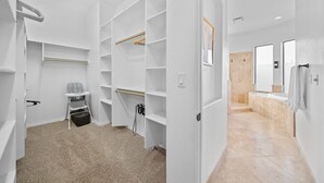 A spacious walk-in closet with multiple shelves and a changing station.