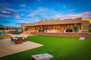 A modern house with a patio, outdoor seating, and a swimming pool.