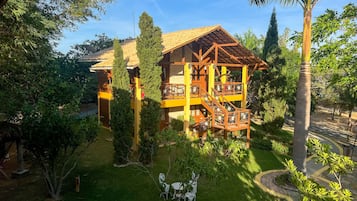 Guests can enjoy a peaceful retreat amidst lush greenery, with a balcony offering a serene view.