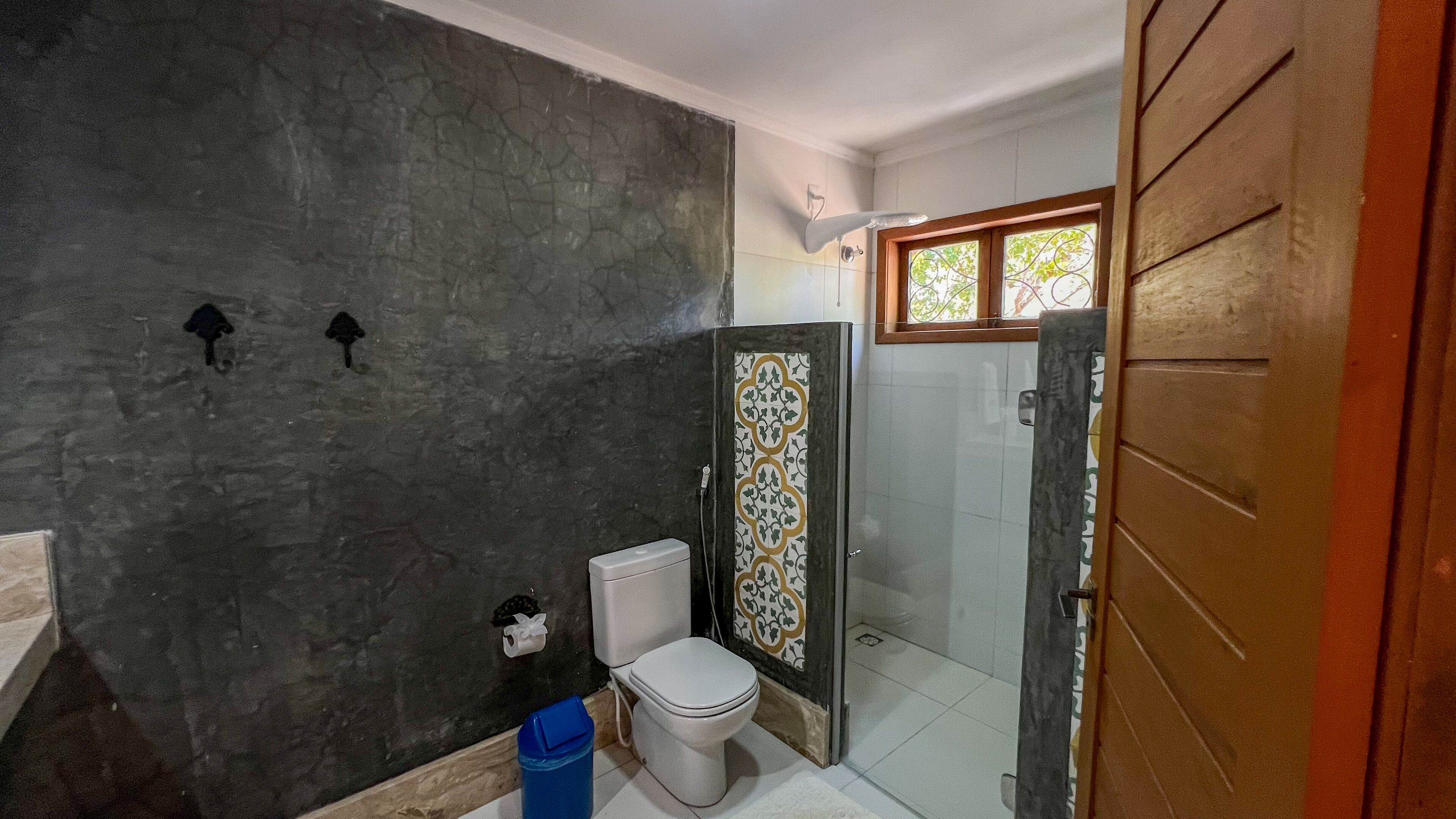 A bathroom with a toilet, a shower, and a sink.