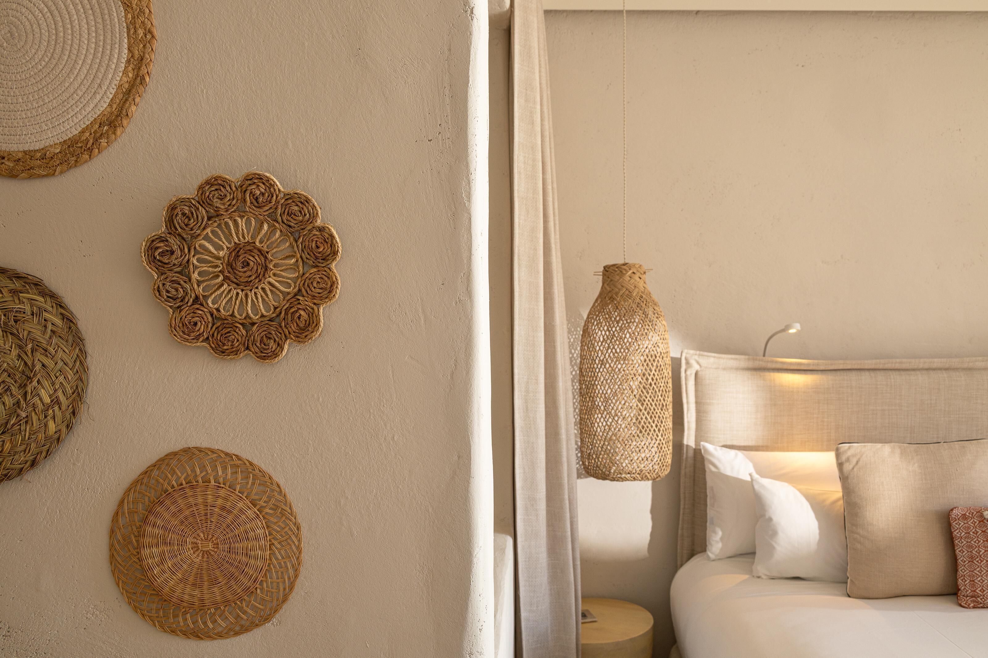 A bedroom with a bed, pillows, and a hanging lamp.