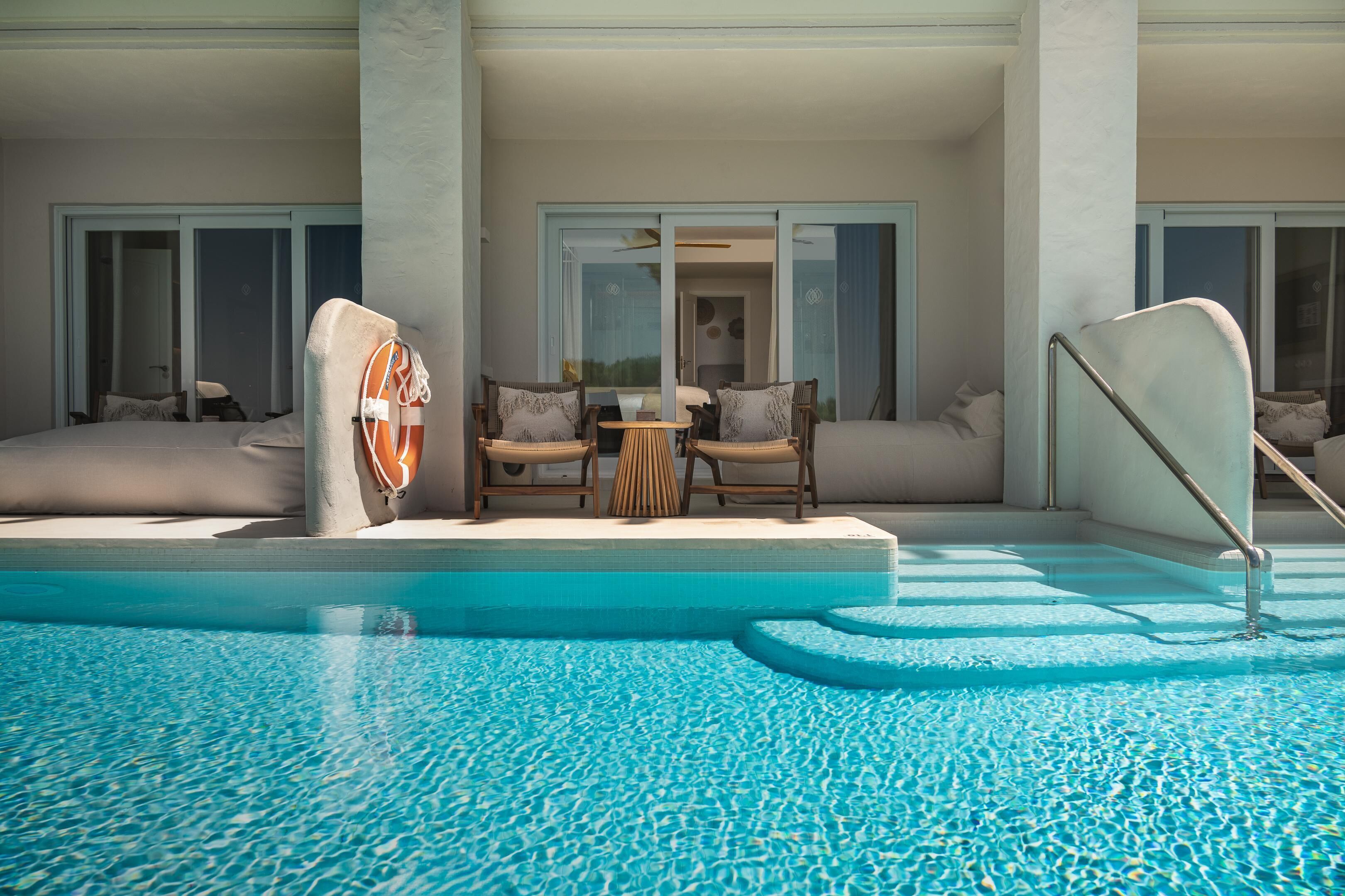 Zona de piscina con mobiliario y vistas al interior.