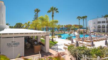 A resort with a pool area, outdoor seating, and a restaurant named 'SALAMAR'.