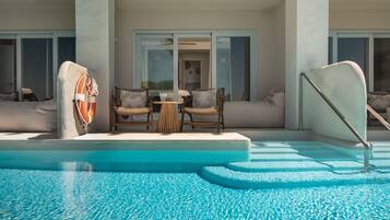 A pool area with a lifebuoy, two wicker chairs, a small table, and a sofa.