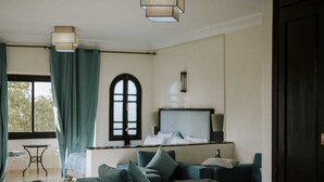 A modern living room with a sofa set, a coffee table, and a TV mounted on the wall. - The les deux palmiers Marrakech Complex (Marrakech)