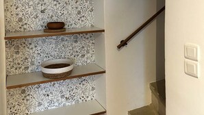 A staircase with a wooden handrail and a sign above stating "HAPPINESS IS THAT WAY".