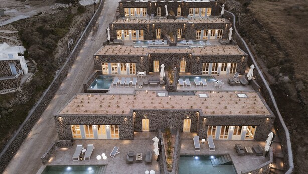 A multi-story resort with multiple pools, outdoor seating areas, and a stone facade. - Almarossa Villas (Santorini)