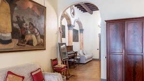 A living room with a sofa, a wooden cabinet, and a painting on the wall. - Suites Rome (Rome)
