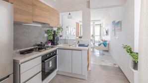 Een moderne keuken met witte kasten, een ingebouwde oven en een centraal keukenblok.