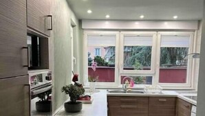 Una cocina moderna con armarios de madera, una isla central y un ventanal con vistas al exterior.