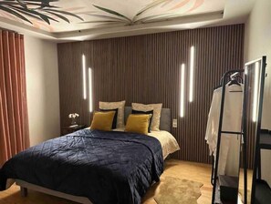 Ein Schlafzimmer mit einem Bett, einem Nachttisch, einem Spiegel und einem Kleiderschrank.