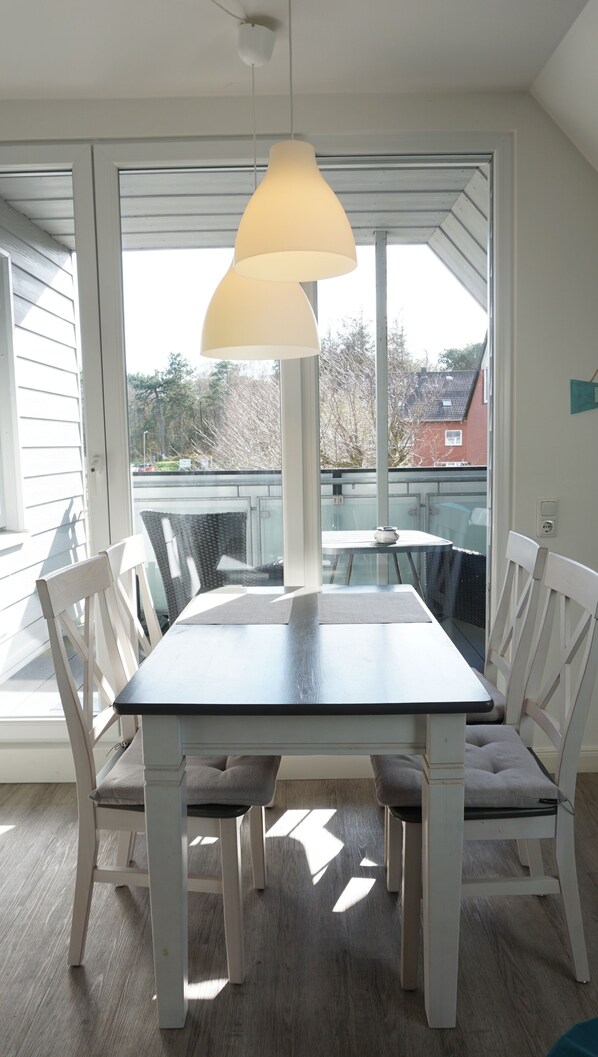 Enjoy meals in this dining area with a table for four, comfortable chairs, and a pendant light fixture.