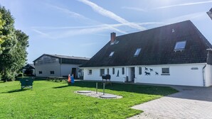 A building with a sloped roof and a white exterior. - Appartement "reiterhof Immensee H" in St. Peter-ording für bis zu 5 Personen (St. Peter-Ording)