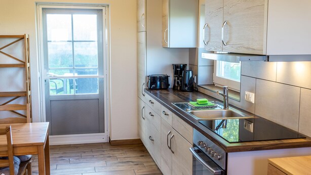 A compact kitchen with a built-in oven, a coffee maker, and a toaster. - Appartement "reiterhof Immensee H" in St. Peter-ording für bis zu 5 Personen (St. Peter-Ording)