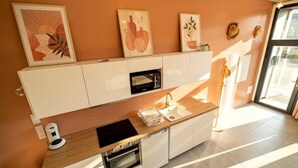 Une cuisine moderne dotée d’un plan de travail en bois, d’un four encastré et de meubles de rangement blancs.
