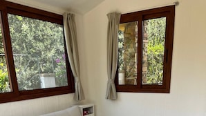 Una sala moderna con un sofá beige, un aparador de madera y una pila de maletas antiguas.