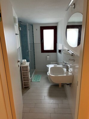 Een douche, een haardroger, een bidet, handdoeken