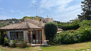 Una casa con techo de tejas, un balcón y un jardín con losetas que conducen a la entrada.