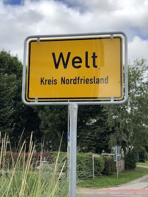 A yellow sign with black text reading "Welt Kreis Nordfriesland".