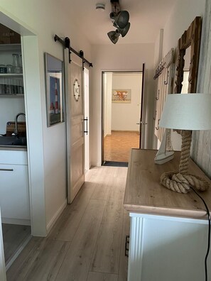 Stunning hallway leads to a dining area with a wooden table and chairs.