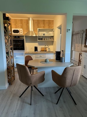 Enjoy cooking in this well-equipped kitchen with a central island, oven, and stainless steel range hood.
