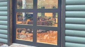 A window with a black frame and six panes, reflecting a rocky outdoor landscape. - New! Secluded Cabin w/ Hot Tub, close to Solitude & Brighton Ski Resorts (Brighton)