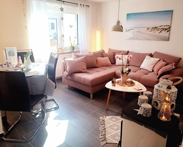 A modern living room with a sofa, coffee table, and decorative items.