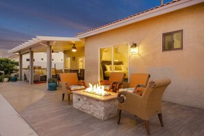 An outdoor patio with a fire pit, wicker chairs, and a pergola. - Dulce Vida: Pool, Spa, Table Games, Fire Pit, BBQ! (Indio)