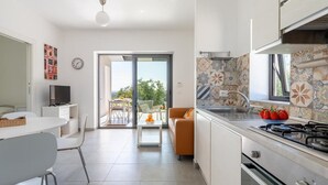 Een moderne keuken met een gasfornuis, een spoelbak en een eethoek met een tafel en stoelen.