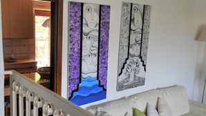 A living room with a white sofa, a staircase, and two abstract paintings on the wall. - Casa Francesca 2 - Private villa with two terraces (Sperlonga)