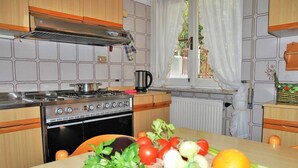 A kitchen with a stove, oven, and a table with fresh vegetables. - Casa Francesca 2 - Private villa with two terraces (Sperlonga)