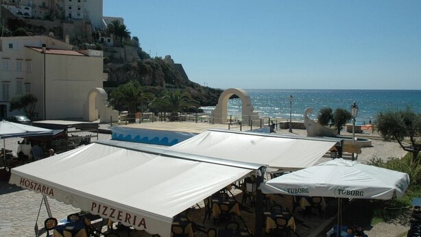 Outdoor seating with umbrellas, a coastal view, and a building with a sign reading "TUBORG". - Casa Francesca 2 - Private villa with two terraces (Sperlonga)