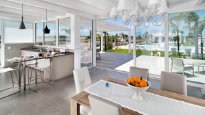 Una cocina moderna con comedor, piscina y vistas al exterior.